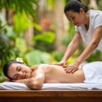 Kvinde får regelmæssig thaimassage med blide tryk og stræk i roligt, naturligt miljø