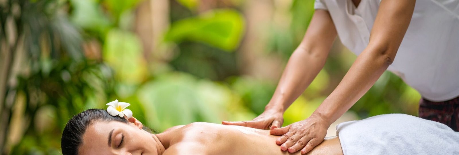 Kvinde får regelmæssig thaimassage med blide tryk og stræk i roligt, naturligt miljø