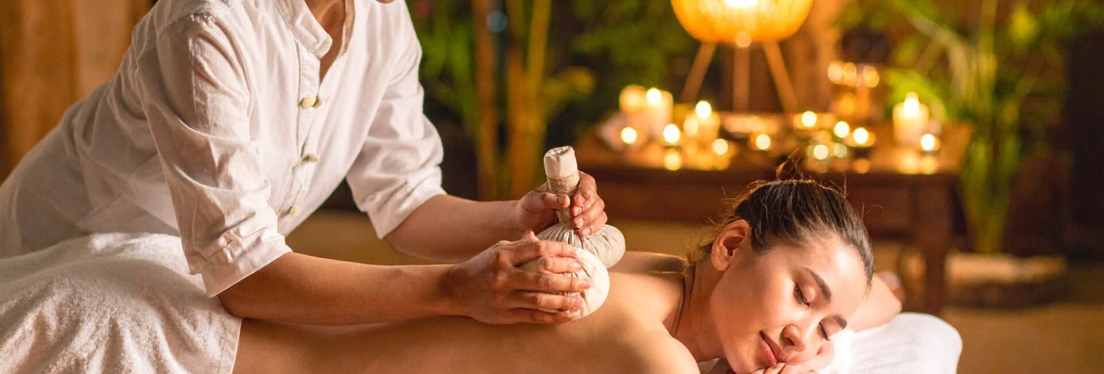 Thaimassør bruger urtekompres og olier under traditionel thaimassage