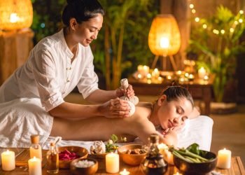 Thaimassør bruger urtekompres og olier under traditionel thaimassage